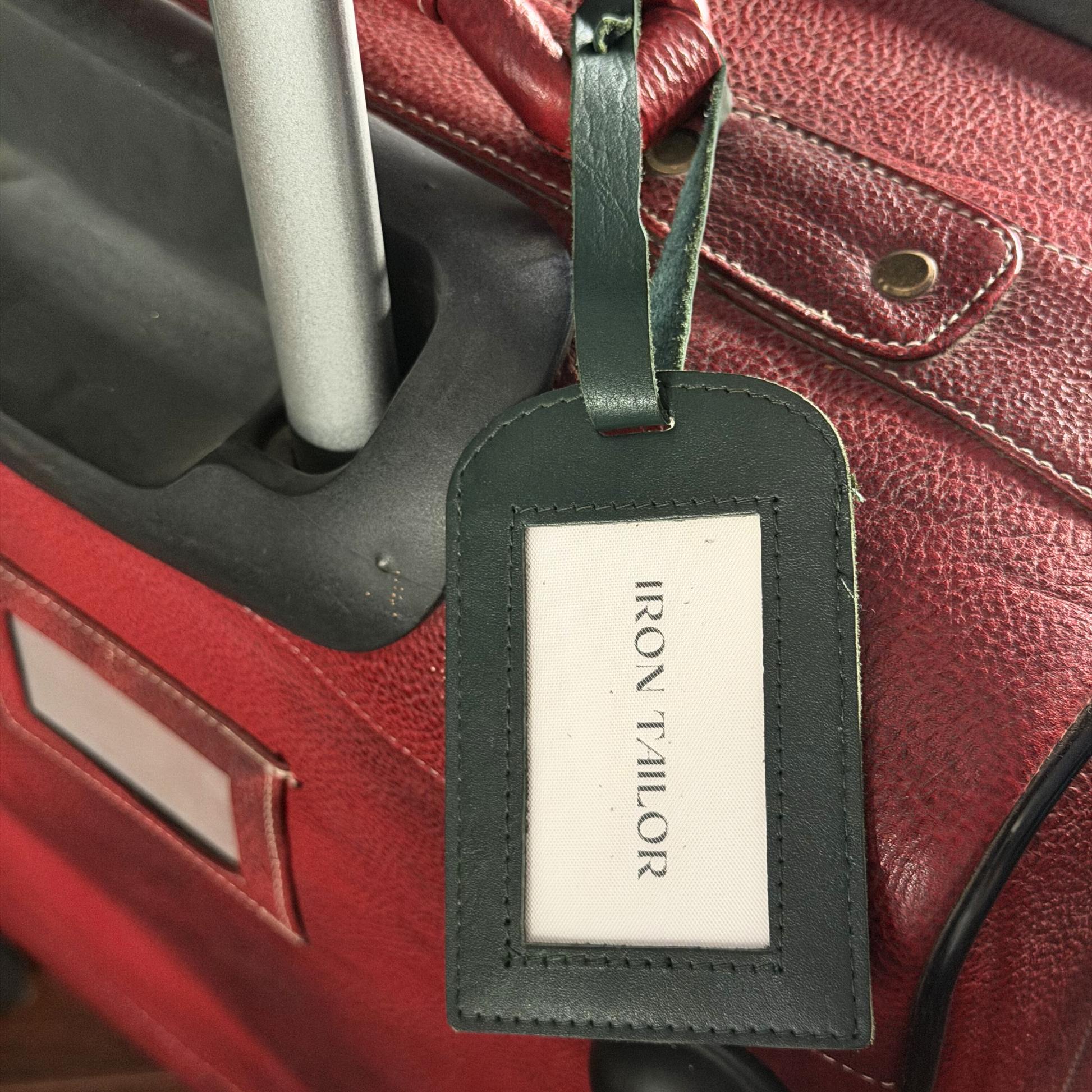 Green Leather Luggage Tag Attached to Suitcase | Iron Tailor